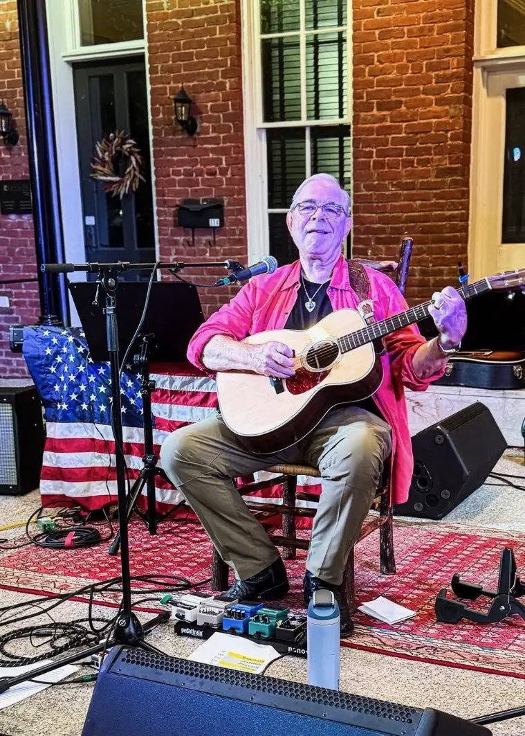 Dave Miller performing outdoors with American flag